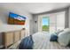 Bedroom with a bed, dresser, TV, and balcony with views of the surrounding greenery at 4535 W 50Th Ave, Denver, CO 80212