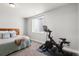 Bedroom with exercise bike, full size bed, neutral wall paint and carpet, and a window for natural light at 4535 W 50Th Ave, Denver, CO 80212