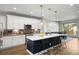 Bright, modern kitchen featuring white cabinets, a large island with seating, and pendant lighting at 4535 W 50Th Ave, Denver, CO 80212
