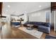 Open-concept living space with hardwood floors, a sectional sofa, and a view of the modern kitchen at 4535 W 50Th Ave, Denver, CO 80212