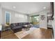Bright living room with hardwood floors, a comfortable gray sectional sofa, and sliding glass doors to the patio at 4535 W 50Th Ave, Denver, CO 80212