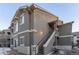 Exterior view of a two-story townhome with stairs and a small patio area at 4538 Copeland Loop # 202, Highlands Ranch, CO 80126