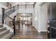 Welcoming entryway with dark hardwood floors and a staircase leading to an open living area at 6679 Kenzie Cir, Castle Pines, CO 80108