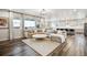 Bright, open living room with large windows, hardwood floors, and seamless access to the kitchen at 6679 Kenzie Cir, Castle Pines, CO 80108