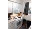 Kitchen featuring white appliances, range, and cabinets with window and modern microwave at 3626 S Granby Way # L03, Aurora, CO 80014