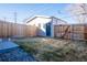 View of the fenced backyard area, featuring a shed, a small patio area, and a patch of dormant grass at 4341 N Columbine St, Denver, CO 80216