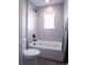 Bright bathroom featuring a white bathtub, gray tile surround, and sleek black fixtures at 4341 N Columbine St, Denver, CO 80216