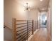 Upstairs hallway with modern lighting, wood railing and a view into a bedroom at 4341 N Columbine St, Denver, CO 80216