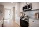 Modern kitchen with white cabinets, stainless steel appliances, and sleek black hardware at 4341 N Columbine St, Denver, CO 80216