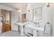 Elegant bathroom with double pedestal sinks, glass shelves, and a classic design at 1433 E 7Th Ave, Denver, CO 80218