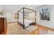 Main bedroom with four-poster bed, hardwood floors, and a view of the treetops at 1433 E 7Th Ave, Denver, CO 80218