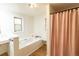 Serene bathroom features a soaking tub with a built-in bench, enhancing relaxation and comfort at 2795 Se Grapevine Rd, Idledale, CO 80453