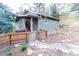 Charming home with a stone path leading to the front entrance, surrounded by lush greenery and privacy fence at 2795 Se Grapevine Rd, Idledale, CO 80453