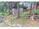 Beautiful home nestled on a hillside, featuring a stone foundation and a natural, wooded setting at 2795 Se Grapevine Rd, Idledale, CO 80453