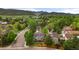 Aerial view showcases the home's backyard, large deck, lush greenery, and mountain views at 8140 S Storm King Peak, Littleton, CO 80127