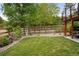 Well-maintained backyard featuring a lush lawn, mature trees, and a charming wooden fence at 8140 S Storm King Peak, Littleton, CO 80127