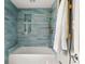 Stylish bathroom featuring a tub with blue tiling and bronze fixtures and recessed niche at 8140 S Storm King Peak, Littleton, CO 80127