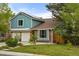 Charming two-story home with blue siding, brick accents, attached two-car garage, and well-manicured front lawn at 8140 S Storm King Peak, Littleton, CO 80127