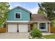 Charming two-story home with blue siding, brick accents, attached two-car garage, and manicured landscaping at 8140 S Storm King Peak, Littleton, CO 80127