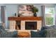 A cozy stone fireplace with a rustic wood mantel creates a warm focal point in the living room at 8140 S Storm King Peak, Littleton, CO 80127