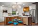 Bright and airy kitchen with an island, stainless steel appliances, custom range, and decorative chandelier at 8140 S Storm King Peak, Littleton, CO 80127