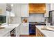 Modern kitchen featuring white cabinets, quartz countertops, stainless steel appliances, and a custom range at 8140 S Storm King Peak, Littleton, CO 80127