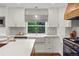 Modern kitchen featuring white cabinets, quartz countertops, stainless steel appliances, and a custom range at 8140 S Storm King Peak, Littleton, CO 80127