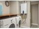 Functional laundry room with side by side machines, folding table and decorative clock at 8140 S Storm King Peak, Littleton, CO 80127