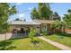Charming backyard featuring a carport, brick garage and vibrant greenery, creating a private outdoor oasis at 4705 Upham St, Wheat Ridge, CO 80033