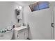 Small bathroom with a pedestal sink, toilet, mirror, and a small window at 4705 Upham St, Wheat Ridge, CO 80033