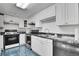 Kitchen with white cabinets, stone countertops, and stainless steel appliances at 4705 Upham St, Wheat Ridge, CO 80033