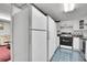 Kitchen with white appliances and blue flooring, plus a seating area at 4705 Upham St, Wheat Ridge, CO 80033