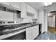 Kitchen with white cabinets, tile backsplash, and black appliances at 4705 Upham St, Wheat Ridge, CO 80033