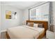 Cozy staged bedroom with warm tones, modern decor, and ample natural light at 1733 Irving St # 101, Denver, CO 80204