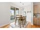 Inviting dining area with sliding glass door to balcony, modern light fixture, and hardwood floors at 1733 Irving St # 101, Denver, CO 80204