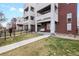 Inviting townhome features a charming porch swing and well-maintained front yard with a sidewalk at 1733 Irving St # 101, Denver, CO 80204