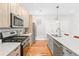 The kitchen features stainless steel appliances, wood cabinets, quartz countertops, subway tile backsplash, and an island with a sink at 1733 Irving St # 101, Denver, CO 80204
