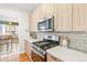 Close up of the kitchen features stainless steel range, microwave, and light wood cabinetry at 1733 Irving St # 101, Denver, CO 80204
