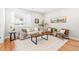 Bright living room with neutral paint, a modern sofa, armchairs, hardwood floors, and a large window at 1733 Irving St # 101, Denver, CO 80204
