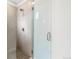 Modern glass enclosed shower featuring neutral tile, a rain shower head, and sleek hardware at 1733 Irving St # 101, Denver, CO 80204
