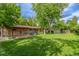 Large backyard with lush lawn, pergola-covered patio, mature trees at 5890 W Quarles Dr, Littleton, CO 80128