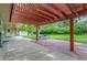 Spacious covered patio with a red pergola, garden beds, brick and concrete at 5890 W Quarles Dr, Littleton, CO 80128