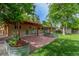 Spacious backyard with red pergola covered patio and beautiful landscaping at 5890 W Quarles Dr, Littleton, CO 80128