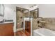 Bathroom featuring tub, tiled shower, granite counters, and wood vanity at 5890 W Quarles Dr, Littleton, CO 80128