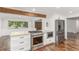 Island kitchen featuring stainless steel stove and appliances, granite countertops, and a decorative wood beam at 5890 W Quarles Dr, Littleton, CO 80128