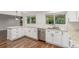 Bright kitchen with stainless steel dishwasher, sink, white cabinetry and granite countertops at 5890 W Quarles Dr, Littleton, CO 80128