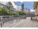 Outdoor wooden deck with metal chair set, overlooking landscaped backyard and mature trees at 10440 Olathe, Commerce City, CO 80022