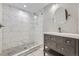 Modern bathroom featuring tiled shower with glass partition, vanity with a round mirror at 10440 Olathe, Commerce City, CO 80022