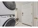 Laundry with new stackable washer and dryer on decorative tile floor, bench and storage at 10440 Olathe, Commerce City, CO 80022