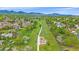 Picturesque aerial view of a neighborhood with a green belt, walking path, playground, and mountain backdrop at 10389 W Fair Ave # E, Littleton, CO 80127